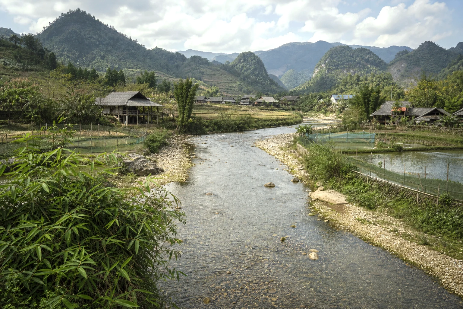 River valley with bamboo, stilt houses and limestone hills in Du Gia