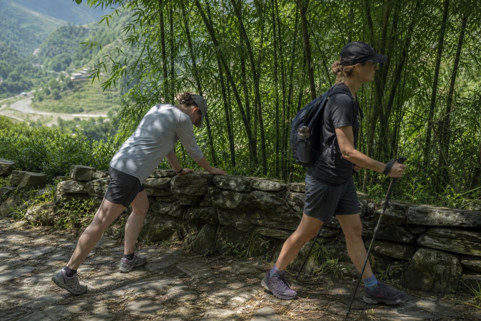 Trekkers resting on a shaded bamboo forest path during a multi-day walk
