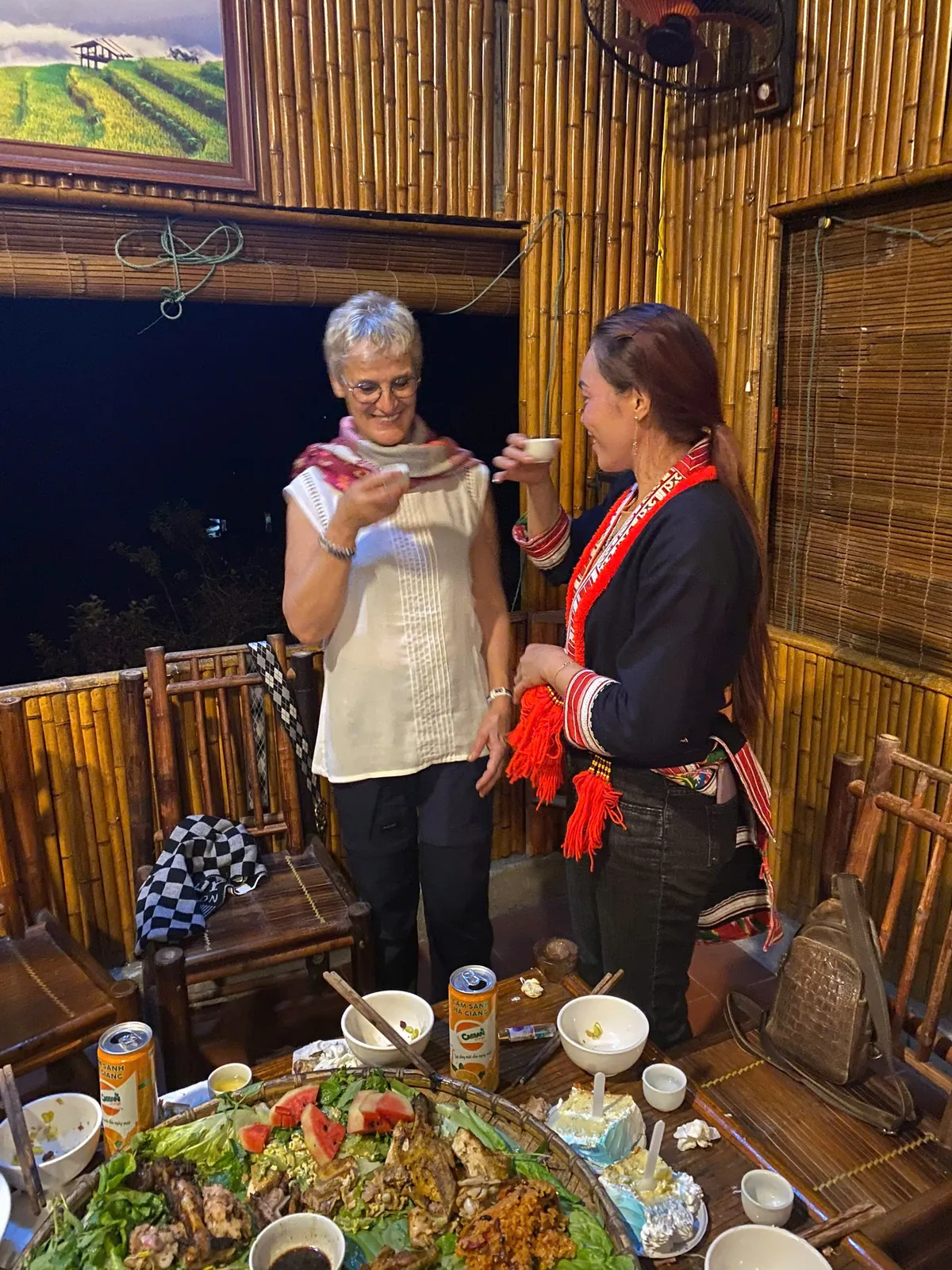 Guests and hosts share a meal at a Red Dao homestay table near Nam Hong, Hoang Su Phi.