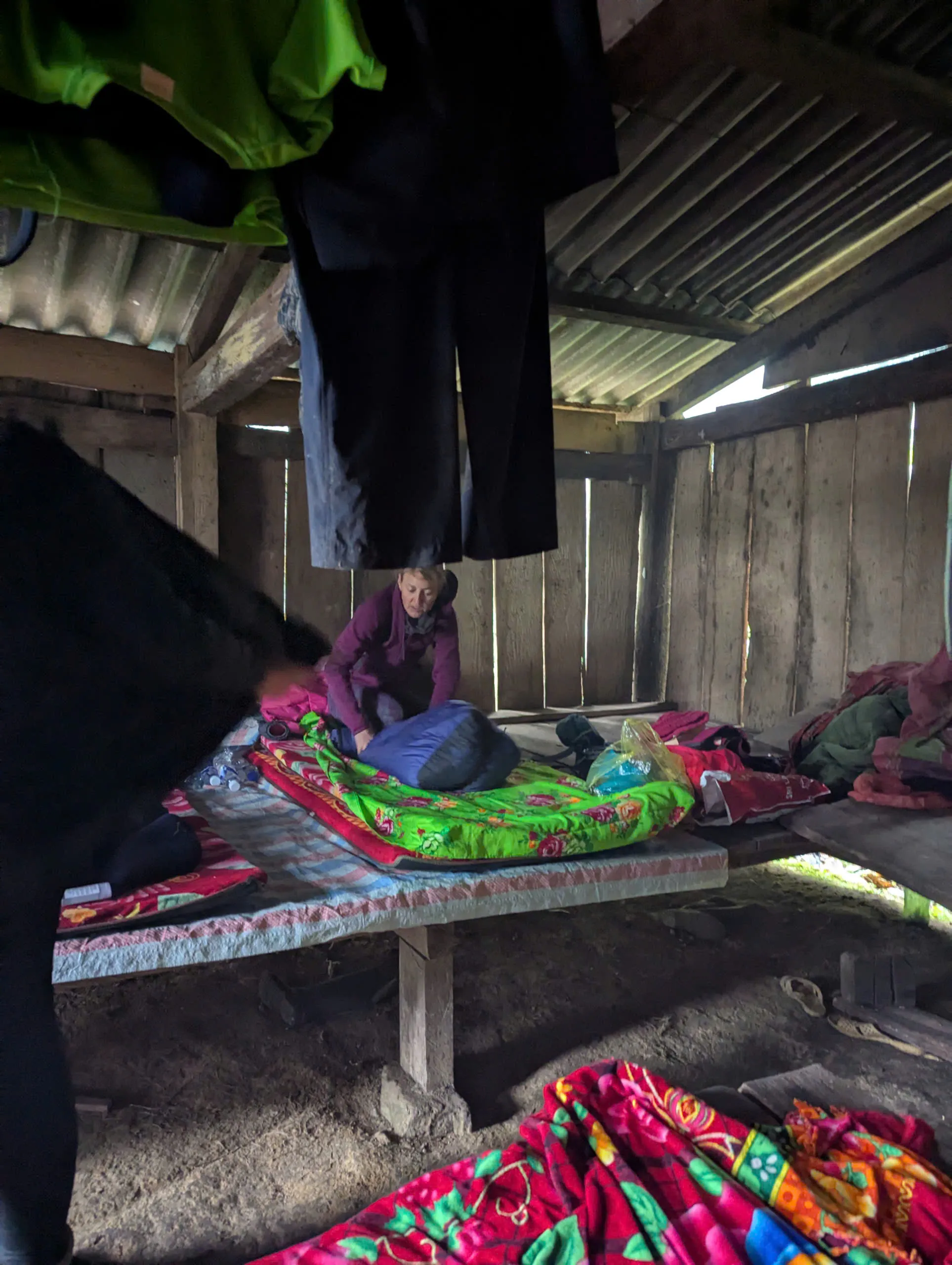 Overnight sleeping area in a forest shelter with sleeping bags and warm blankets visible.
